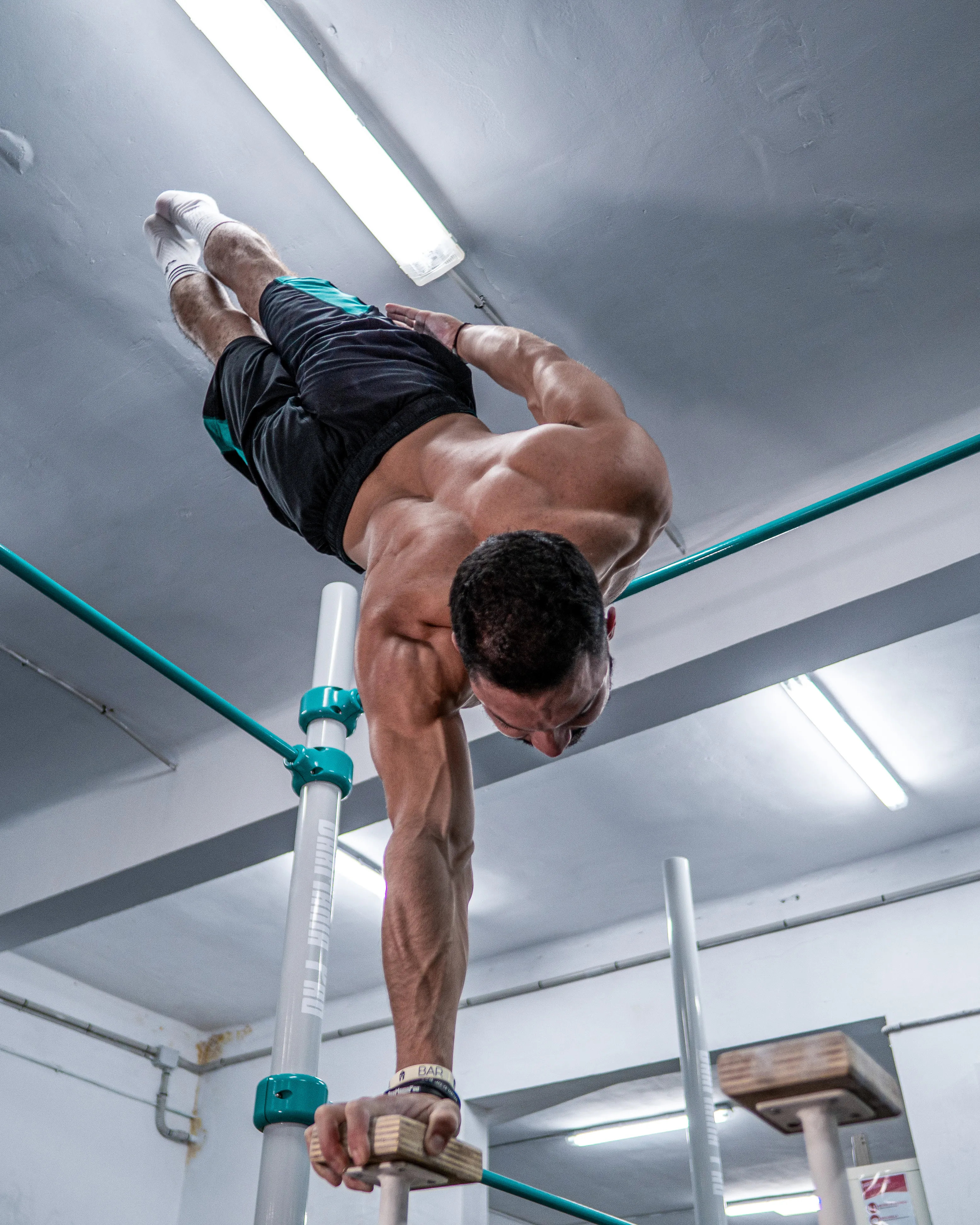 Jhonnatan realizando un movimiento avanzado de calistenia invertido en barras