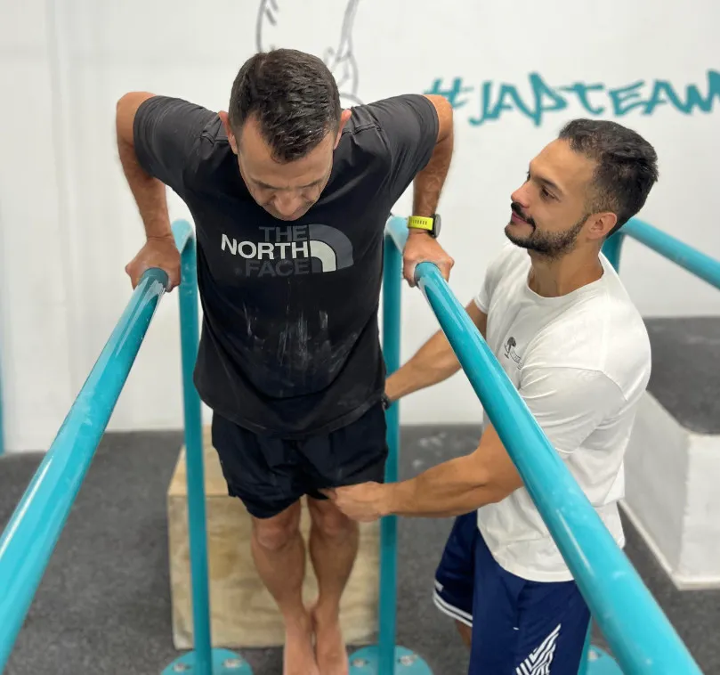 Dos atletas entrenando en paralelas con el hashtag JAPTEAM